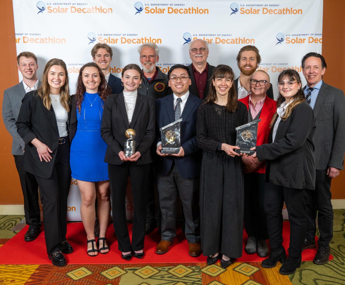 Members of the Solar Decathlon teams pose with their trophies.